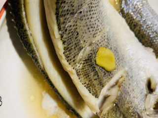 10、葱油鲈鱼,蒸好的鲈鱼，先出锅，倒掉蒸鱼的汁；