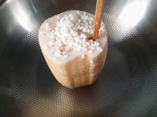 5、#为家乡菜爆灯#红枣糯米藕,将泡好的糯米慢慢填入莲藕中、一边填一边用筷子捅结实一点