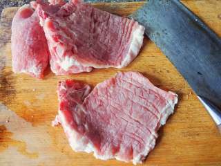 2、红烧香葱大排,洗干净大排，沥干水分，用刀背敲松大排，正反两面都需要，切断肥膘白膜链接处，放盆里备用