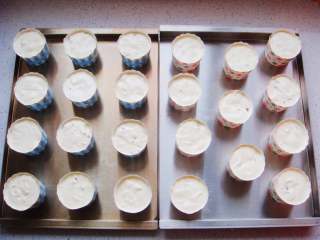 13、红枣葡萄干蛋糕杯,翻拌均匀后，装入裱花袋。把纸杯提前放在烤盘里，挤入纸杯中8分满。（图中是大号纸杯）