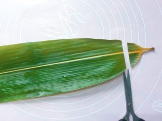 6、红豆红枣牛角粽,开始包粽子:取一张粽叶,用厨房专用小剪刀修剪两头;