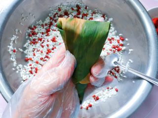 12、红豆红枣牛角粽,先把两边的粽叶往中间压,再把顶端的粽叶往下折;