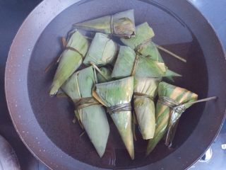 15、红豆红枣牛角粽,全部包好后放入煮锅,加入足量的清水(水一定要没过粽子),大火煮开转中小火煮一个小时,煮好以后在锅里再焖两个小时后捞出,口感更黏糯。