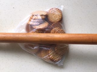 5、奶油红薯蛋糕条,把饼干装进保鲜袋里，袋口松松的打个结，用擀面杖轻轻地来回滚动