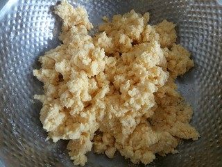 6、玉米面发糕,玉米面中倒入开水,一边倒一边用筷子搅拌成絮,达到无干粉的状态。然后放凉。这就是烫面,这样可以让发糕更软!(一定是刚烧开的开水哦!)