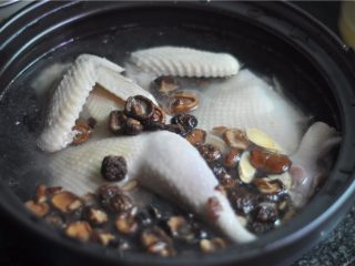 9、砂锅炖鸡,将香菇和黄芪放进去