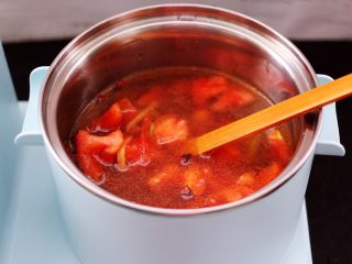 8、虾滑番茄豆干汤,早餐机的汤锅里加入适量的清水,把翻炒好的番茄倒入锅中。
