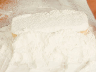 17、玫瑰云片糕,在糕上撒熟糯米粉，把整个糕埋在熟糯米粉内。