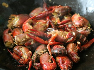 13、≈湖北油焖大虾≈,锅内倒入油,下入小龙虾,翻炒至变红