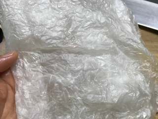 6、盐焗鸡,先在一张纱纸上均匀地刷上一层油。