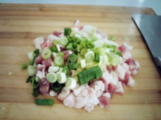 11、南瓜猪肉豇豆包子,切好的葱姜放在猪肉陷上聚续剁陷。