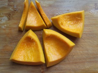 4、金瓜黑米饭,然后把它从中间切十字，切成四块，每块纵向长约8厘米；