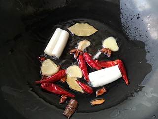 8、东北酱大骨,另取一锅加入适量油烧热下葱姜八角，干辣椒，香叶爆出香味。