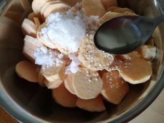 6、美味烤红薯片,再倒入两勺玉米油。