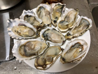 2、蒜蓉生蚝,生蚝蚝壳刷洗干净,用开蚝刀撬开,冲洗点蚝肉里的泥沙,摆盘备用