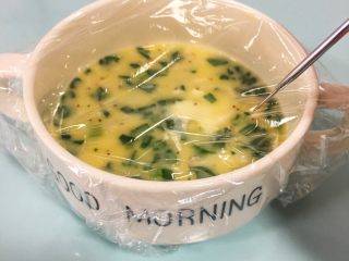 9、宝宝辅食：10M➕：青菜虾皮鸡蛋羹,用耐高温保鲜膜将盛有蛋羹的容器包裹上，拿针扎几个小孔