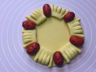 7、枣花馍,如图：把佛手的中间3根手指捏在一起向下折，再将做好的佛手和红枣依次摆放在底盘上（红枣提前泡发 2分钟，然后清洗干净备用）。