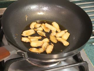 6、酒香麻油鸡油饭,再放入黑麻油4大匙爆香。黑麻油不耐高温,所以先用白麻油煸姜,以免产生苦味。