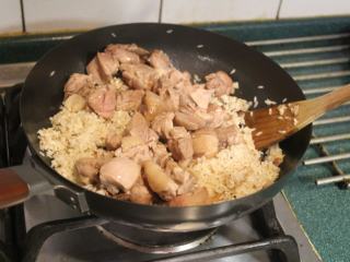 9、酒香麻油鸡油饭,将鸡肉也放入,翻炒。