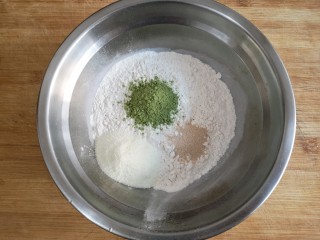 1、抹茶蜜豆华夫饼,在高粉中加入抹茶粉，奶粉，酵母粉搅拌均匀。