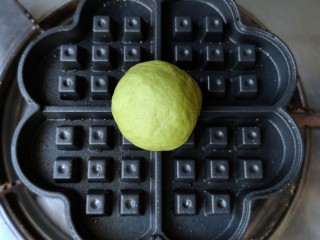 12、抹茶蜜豆华夫饼,华夫饼锅子预热一下，取一个剂子放在正中，盖好（如果不将就形状的同学，可以根据自己华夫饼锅子的大小，一次多放几个剂子）。