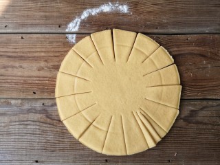 6、春暖花开,将南瓜面团擀成约8寸，厚5-7毫米的圆饼，先等分切成16份，再将每份等分切成3份，如图。