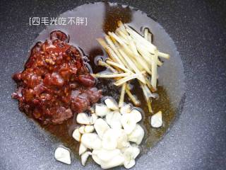 4、水煮牛肉,热油,倒入郫县豆瓣酱和姜丝和蒜片炒至香味出来;