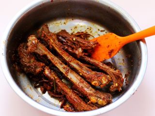 14、烧烤风味烤羊排,把腌制好的羊排倒入花生油再次拌匀。