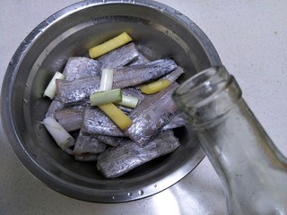 6、香煎带鱼,倒入料酒。