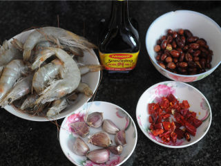 1、宫保凤尾虾,所有的食材准备好，花生炒熟，干辣椒切成段，大蒜用刀拍碎去皮，姜切片备用