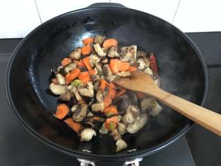 9、黄焖香菇,放入胡萝卜翻炒。
