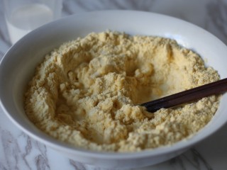 4、红枣奶香窝头,牛奶分几次缓缓倒入面粉中，用筷子搅拌。