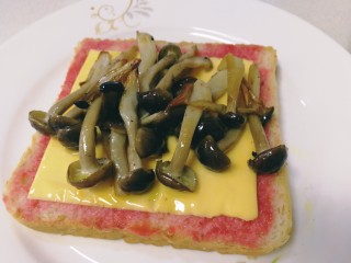 8、鸡蛋芝士全麦三明治,把煎好的蟹味菇放在芝士片上。