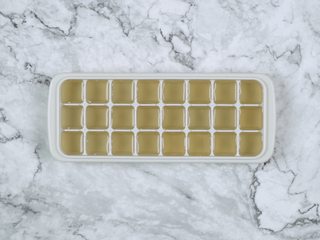 4、消暑仙草水果冰粥,将糖水倒入冰格,放入冰箱冷冻,冷冻好取出,倒入料理机中,捣成碎冰,装碗