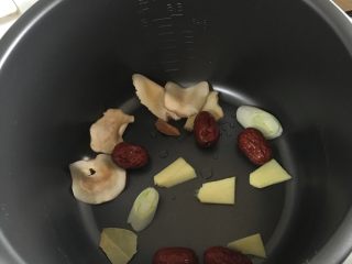 2、电饭煲版玉米炖排骨,电饭煲中放入葱段、生姜、海底椰、红枣、香叶和桂皮。