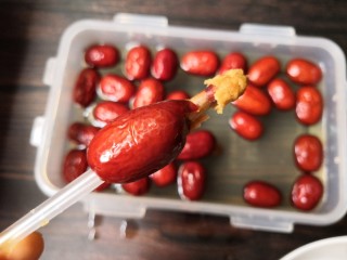 3、百变水果 百香果味糯米酿红枣,用力往前推,让吸管穿过红枣。