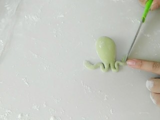 6、蹦蹦跳的小蛙花样馒头,盘曲出后腿的样子，然后用刀划出蛙蹼。