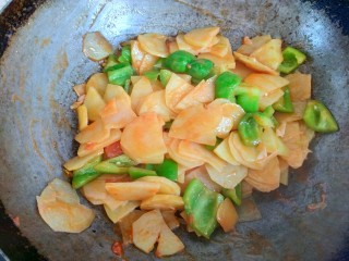 10、西红柿青椒土豆片,加入青椒翻炒一会儿，西红柿完全变成汁，浸入到土豆片中，翻炒均匀关火出锅