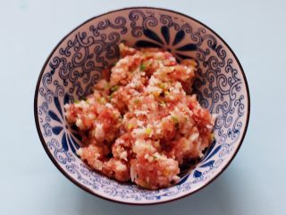 5、灯笼茄子,把搅拌好的肉馅放入一个大一点的容器里。