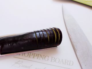 9、灯笼茄子,茄子放在菜板上，然后底下放上筷子，这样茄子就不会被断。