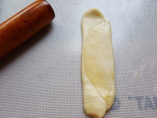 9、芝麻烧饼,9．再取出一个面团，先用手轻微压扁，然后用擀面杖擀开。