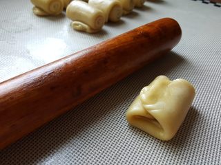 12、芝麻烧饼,12．进行一个三折，折成小的长方形，再用擀面杖擀薄。