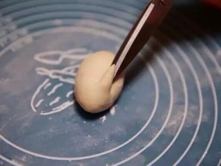 6、新年喜庆花样馒头,用大一些的剪子在面团尖端1/4处，剪出兔子的长耳朵。