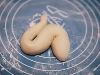 9、新年喜庆花样馒头,小龙馒头：称量好130克面团，搓成长条状，头部圆，越到尾部越细，将面条盘成S状。