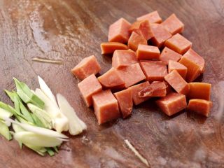 3、火腿炖白菜,火腿用刀切成小方块，蒜苗去皮后斜切丝。