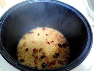 4、红枣糯米饭,盖上电饭煲开始煮～这是半熟的样子