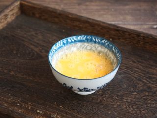 8、木耳菠菜炒鸡蛋,将鸡蛋磕入碗里，用筷子打散。