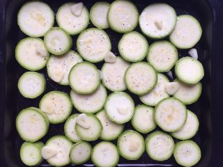 2、烤菇菇蛋吐司配节瓜,将节瓜放入烤盘中，放上蒜片、撒上适量的橄榄油、海盐和黑胡椒。烤箱预热190度，放入烤箱中层烤25分钟（烤节瓜期间准备菇菇蛋吐司）