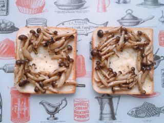 9、烤菇菇蛋吐司配节瓜,刷好油的吐司中间按压出一个圆形凹陷，将炒好的蟹味菇围着凹陷均匀码放在吐司上