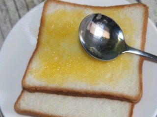 11、猪肝火腿煎蛋三明治,把黄油涂抹在上面，两片都涂好